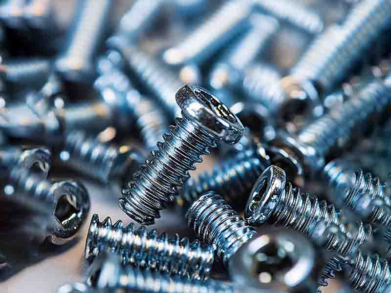 Close-up image of custom screws showcasing detailed threads, high-quality finishes, and various screw head types like flat, round, and pan head, emphasizing precision in screw manufacturing